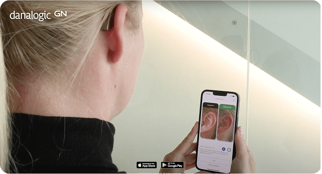Building up to wearing your hearing aid through out the day. Lady ready the documentation and instructions via the app.